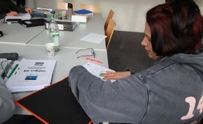 Eine Teilnehmerin sortiert ihre Unterlagen während des Vorbereitungskurses für den Fahrdienst bei der MVG im bfz.