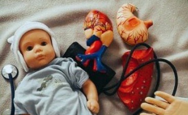 News- Bild: Puppe sowie medizinische Gerätschaften auf einer Decke liegend