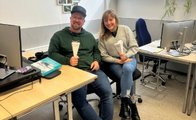 Auf dem Bild sind ein Mann und eine Frau zu sehen. Der Mann trägt eine Schildkappe. Sie sitzen nebeneinander und halten jeweils eine Schultüte in der Hand.