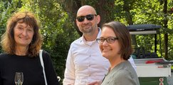 Sommerfest 2026 2 Frauen und ein Mann lächeln in die Kamera im Biergarten