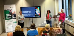 Netzwerkabend im Rahmen der Woche der Seelischen Gesundheit Drei Frauen stehen vor sitzenden Zuhörern und sprechen nacheinander