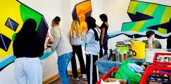 Frauenpower im Graffiti-Projekt Junge Frauen malen einzelne Formen an den Wänden bunt an