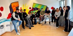 Graffiti-Kunstwerk der BVJ Klasse BV10a in den bfz Starnberg Schüler und Lehrer stehen im Halbkreis vor bunt bemalten Graffitiwänden