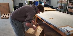 Besuch bei der Firma Suprima Ein Teilnehmer klebt beim Besuch der Firma Suprima einen Karton zu