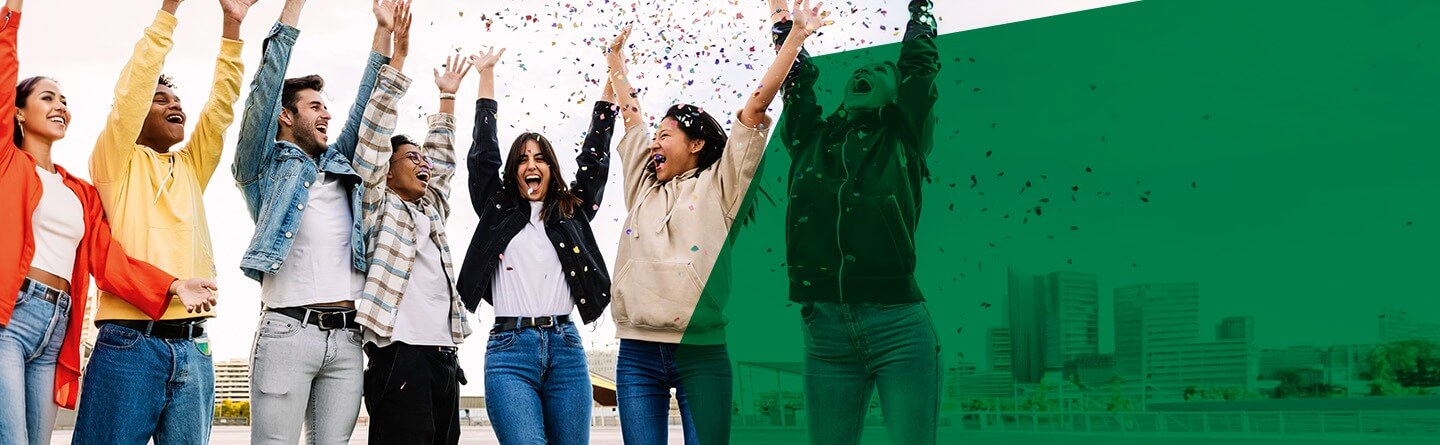 Berufsanerkennung Header: Eine Gruppe junger Menschen jubelt gemeinsam, buntes Konfetti fliegt durch die Luft.