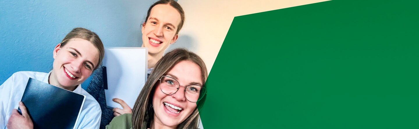 Header: Drei Schüler*innen lachen in die Kamera, zwei von ihnen halten Hefter in den Händen, ein Mädchen hält den Daumen nach oben.