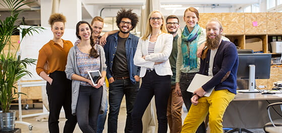 Inhaltsbild: Porträt eine multi-ethnischen Teams, die in einer Gruppe in einem Büro stehen.