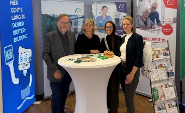 Stand der bfz Alpenvorland bei Jobmesse „meineZukunft!“ mit vier Personen an einem Tisch