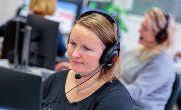 Inhaltsbild: Frau mit Headset vor Computer