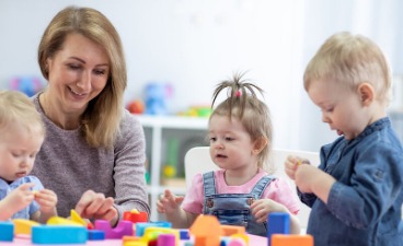 Assistenzkraft bastelt mit Kindern
