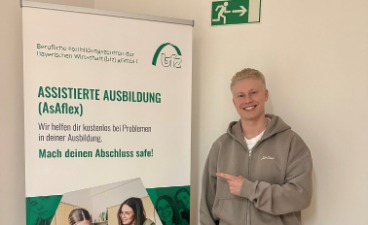 Teilnehmer neben dem AsA flex-Roll-up am bfz Dachau nach erfolgreichem Ausbildungsabschluss