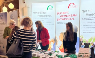 Messestand der bfz mit Mitarbeiterinnen im Beratungsgespräch 