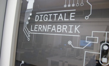 Glastür, auf der Digitale Lernfabrik steht 