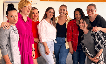 Gruppenfoto mit acht Frauen, die überwiegend lachen. 