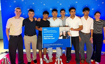 Gruppenbild mit jungen Erwachsenen vor blauem Hintergrund