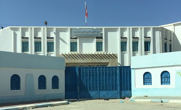 Teaserbild: Außenansicht einer tunesischen Berufsschule mit blau-weißen Mauern und großem blauen Tor