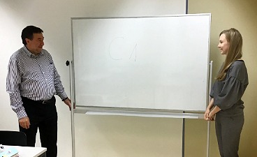 Teaserbild: Teilnehmerin und Lehrkraft stehen vor einem White Board.