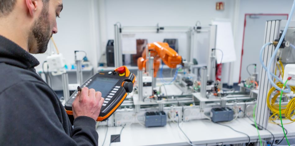 Ein Mann programmiert in der digitalen Lernwerkstatt eine Maschine. 