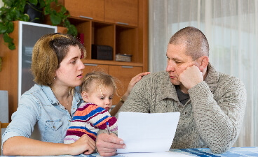 Eine Familie, Vater - Mutter - Kind, sehen sich Rechnungen an