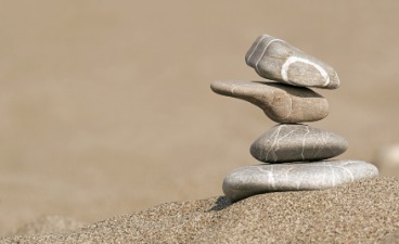 Geschickt aufeinander balancierte Steine im Sand | Foto: fotolia