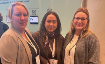 Drei Frauen stehen nebeneinander und schauen in die Kamera. 